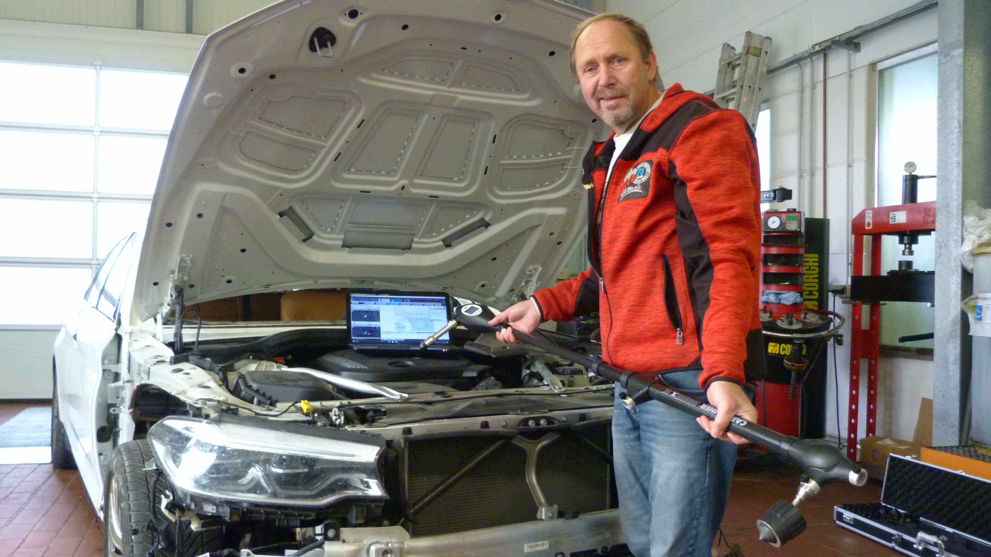 Kfz-Gutachter Andreas Henschel an einem zu vermessenden Fahrzeug